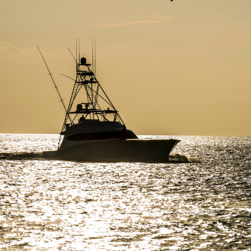 A boat floating calmly on the water, surrounded by gentle waves and a clear sky.
